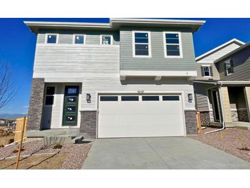 Two story home featuring mixed siding, a two car garage, and modern architectural details at 9237 Truckee Ct, Commerce City, CO 80022