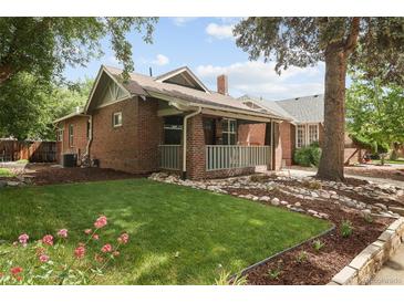 Charming brick home with a welcoming front porch, grassy lawn, and beautiful landscaping at 3039 W Denver Pl, Denver, CO 80211