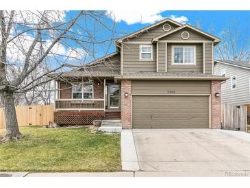 Inviting two-story home showcasing a well-maintained lawn, covered porch, and an attached two-car garage at 5264 E 129Th Pl, Thornton, CO 80241
