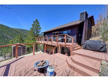 Expansive deck with cozy fire pit and views offers an inviting outdoor living space, perfect for relaxation and entertaining at 617 Hummingbird Trl, Idaho Springs, CO 80452