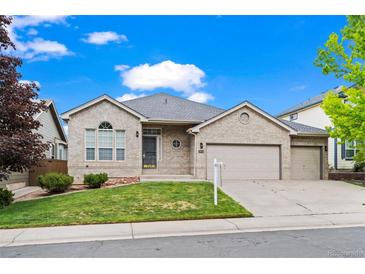 Charming single-Gathering home showcasing a well-manicured lawn and a spacious two-car garage at 9856 Keenan St, Highlands Ranch, CO 80130