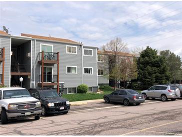 Exterior view of condo building with gray siding, brown trim, and private balcony at 16359 W 10Th Ave # 1, Golden, CO 80401