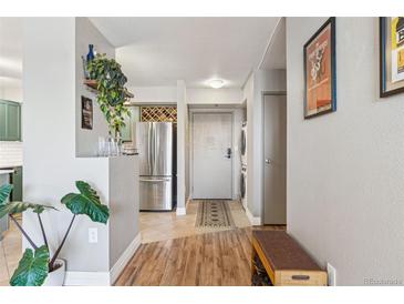 Bright entryway with wood floors, in-unit laundry, and a view into the kitchen at 601 W 11Th Ave # 311, Denver, CO 80204