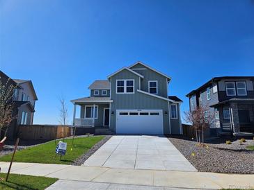 Charming two-story home with a wide driveway, manicured lawn, and a welcoming front porch at 6046 Keyser Pl, Brighton, CO 80601