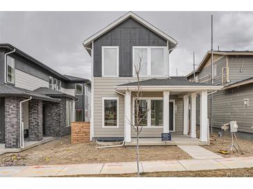 Charming two-story home boasts a welcoming front porch and modern gray and tan siding details at 710 Belay St, Erie, CO 80516