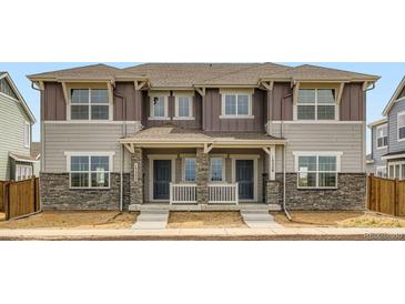 Charming two-story townhome with stone accents and covered front porch at 15228 Detroit St, Thornton, CO 80602