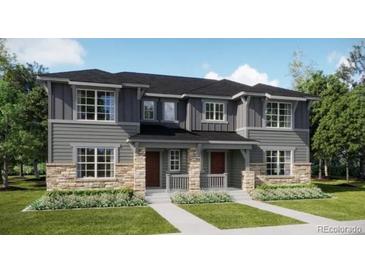 Charming townhome with stone accents, a well-manicured lawn, and inviting covered front porches at 15228 Detroit St, Thornton, CO 80602
