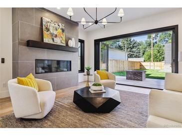 Inviting living room boasts a modern fireplace, stylish decor, and seamless indoor-outdoor flow to the backyard at 2511 S Columbine St, Denver, CO 80210