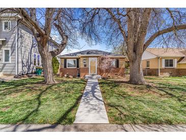 Charming brick home with a well-manicured front yard and a walkway leading to the entrance at 3254 S Bannock St, Englewood, CO 80110
