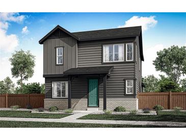 Charming two-story home featuring a green front door, gray siding, and a well-manicured lawn at 5762 N Jebel Way, Aurora, CO 80019