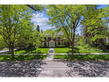 Charming brick home with lush lawn and mature trees; welcoming curb appeal at 2222 E 7Th Avenue Pkwy, Denver, CO 80206