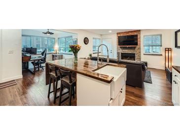 Bright kitchen with wood countertops, white cabinets, and a stainless steel farmhouse sink at 2286 S Pitkin Way # A, Aurora, CO 80013