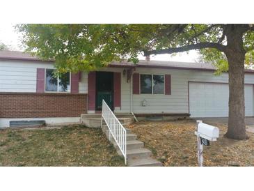 Ranch style home with brick facade, attached garage, and mature landscaping at 3984 S Pitkin Way, Aurora, CO 80013