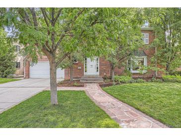 Charming brick home with a beautiful stone walkway leading to the front door and a well-manicured lawn at 30 Eudora St, Denver, CO 80220