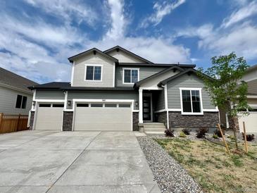Charming two-story home featuring a three-car garage, stone accents, and well-manicured landscaping at 245 Wooten Ave, Brighton, CO 80601