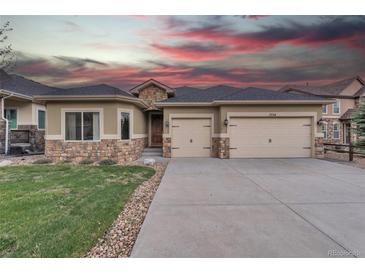 Charming stucco home with a two-car garage and stone accents against a dramatic sky at 9754 W Ontario Pl, Littleton, CO 80128