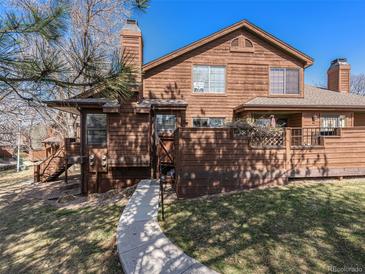 Charming wood-sided home with a walkway leading to the entrance and a well-maintained lawn at 9365 W 80Th Pl # C, Arvada, CO 80005