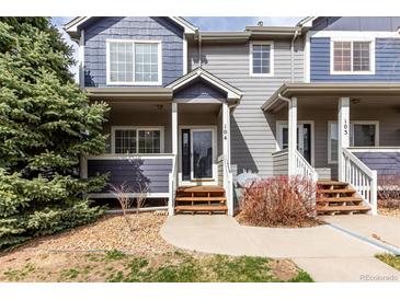 Charming townhome with well-maintained landscaping, inviting entryway and partial view of mature evergreen tree at 19240 E Carolina Dr # 104, Aurora, CO 80017