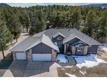 Charming home featuring a stone facade, three-car garage, and a well-maintained yard at 2049 Silverheels Dr, Larkspur, CO 80118