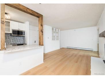 Bright living room featuring hardwood floors and an open floor plan connected to the kitchen at 3035 Oneal Pkwy # 20V, Boulder, CO 80301