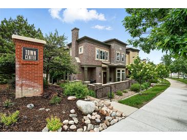 Attractive two-story townhome featuring brick exterior, manicured landscaping, and welcoming front entrance at 681 W Burgundy St # A, Highlands Ranch, CO 80129