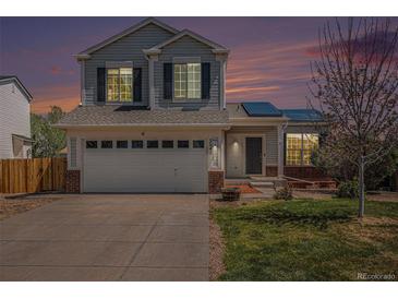 Charming two-story home with a well-manicured lawn, solar panels, and an attached two-car garage at 3543 S Ceylon Way, Aurora, CO 80013