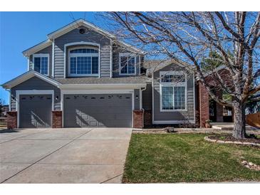 Charming gray two-story home with a well-manicured lawn, two-car garage, and appealing curb appeal at 7087 Sapphire Pointe Blvd, Castle Rock, CO 80108