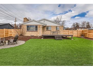 Well-maintained backyard featuring a deck, artificial grass and a firepit area at 8105 W 62Nd Ave, Arvada, CO 80004