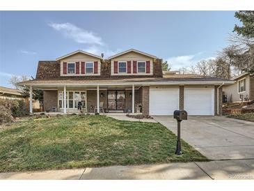 Charming two-story brick home with a well-maintained lawn and attached two-car garage at 8633 E Monmouth Pl, Denver, CO 80237