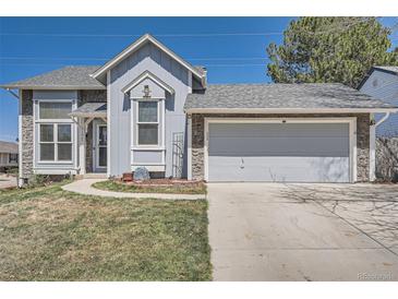 Charming home featuring stone accents, a two-car garage, and a well-maintained front yard at 21367 E Aberdeen Dr, Centennial, CO 80015