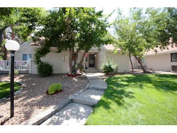 Charming home featuring a landscaped front yard with mature trees and a welcoming walkway to the entrance at 2459 S Xanadu Way # B, Aurora, CO 80014
