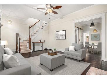 Bright living room features hardwood floors, stairs, ceiling fan and a seamless transition to the dining area at 1020 Kalamath St, Denver, CO 80204