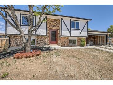 Charming brick home with a two-car garage, black and white trim, and a landscaped front yard at 17979 E Oxford Pl, Aurora, CO 80013