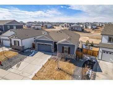 Charming single-Gathering home showcasing neat landscaping, complemented by a concrete driveway leading to an attached garage at 6664 Merrimack Dr, Castle Pines, CO 80108