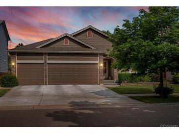 Charming home with a three-car garage, lush landscaping, and a warm, inviting entrance at 5660 S Eaton St, Littleton, CO 80123