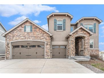 Charming home featuring a stone and stucco facade, multiple car garage, and inviting arched entryway at 2627 Hillcroft Ln, Castle Rock, CO 80104