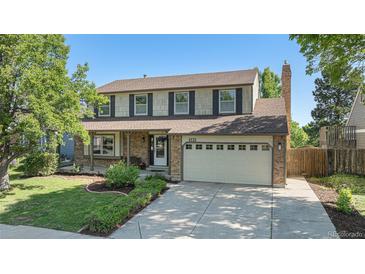 Charming two-story home with landscaped yard, brick accents, and two-car garage at 1121 W Kettle Ave, Littleton, CO 80120