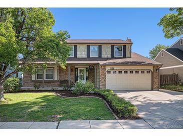 Charming two-story home with landscaped yard, brick accents, and two-car garage at 1121 W Kettle Ave, Littleton, CO 80120