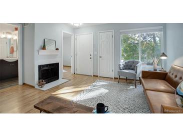 Bright living room with fireplace, hardwood floors, and comfy seating at 1825 Kendall St # 103, Lakewood, CO 80214