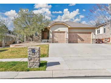 Charming single-story home featuring a two-car garage, stone accents, and manicured front yard at 2885 W 115Th Dr, Denver, CO 80234