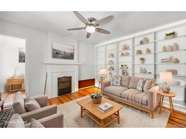Cozy living room features built-in shelves, fireplace, ceiling fan and beautiful hardwood floors at 1137 N Sherman St # 16, Denver, CO 80203