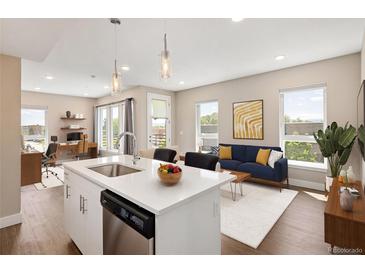 Bright open concept living room and kitchen with stainless steel appliances and hardwood floors at 2374 S University Blvd # 202, Denver, CO 80210