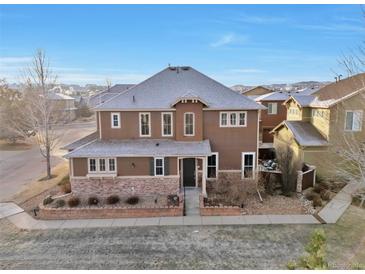 Two-story home with brown siding, gray roof and landscaping at 10555 Ashfield St, Highlands Ranch, CO 80126