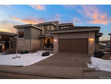 Stunning modern home with a large garage and snow-covered landscaping at 9524 Fork Bluff Pt, Lone Tree, CO 80124