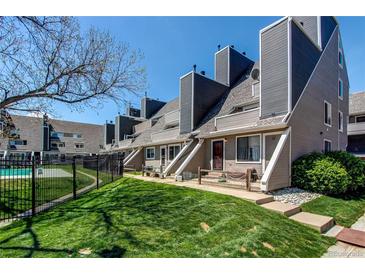 Townhouse exterior featuring well-maintained landscaping, gray-toned paint and black fence at 5250 S Huron Way # 10-207, Littleton, CO 80120