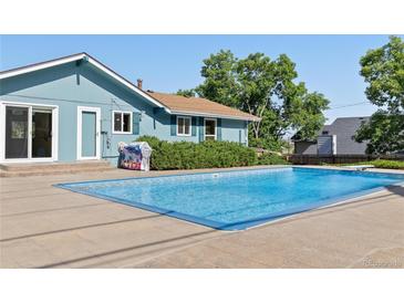 Refreshing blue swimming pool and patio area, perfect for outdoor relaxation and entertaining at 310 S Alkire St, Lakewood, CO 80228