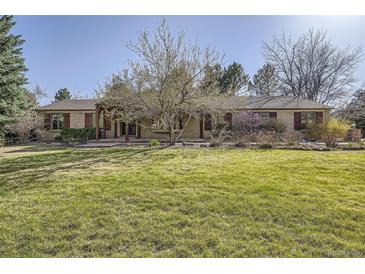 Sprawling ranch-style home with a manicured lawn and mature landscaping at 4401 Sombrero Cir, Littleton, CO 80123