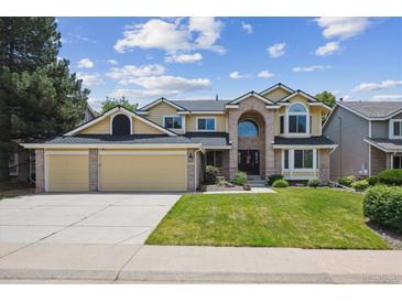 Inviting two-story home with a well-manicured lawn and attached three-car garage at 1762 Red Fox Pl, Highlands Ranch, CO 80126