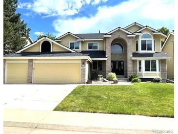 Inviting two-story home featuring a well-manicured lawn and an attached two-car garage at 1762 Red Fox Pl, Highlands Ranch, CO 80126