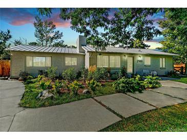Charming single-story home featuring a beautifully landscaped front yard and modern architectural details at 2981 Teller St, Wheat Ridge, CO 80033